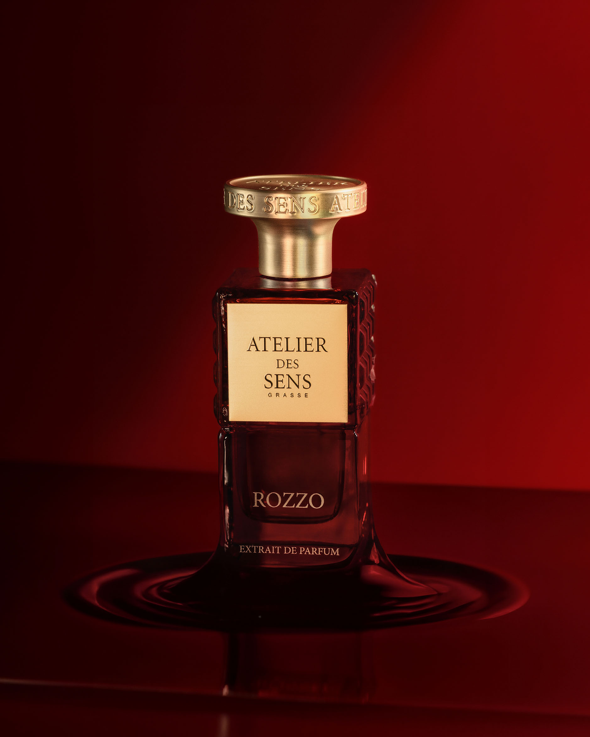 an extrait de parfum bottle of perfume in a red background